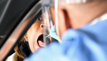 NORTH LAS VEGAS, NEVADA - NOVEMBER 12: Spc. Demetrie Barnett of the Nevada National Guard administers a COVID-19 test to North Las Vegas City Councilwoman Pamela Goynes-Brown during a preview of a free drive-thru COVID-19 testing site in the parking garage of the Texas Station Gambling Hall & Hotel on November 12, 2020 in North Las Vegas, Nevada. The site will open on November 13 amid increased demand for testing due to a surge in coronavirus cases in the state. Over the past two weeks, Nevada has averaged close to 1,000 new coronavirus cases per day, with a 13.7 percent test positivity rate. Clark County is partnering with the Southern Nevada Health District, Nevada National Guard, University Medical Center of Southern Nevada, city of North Las Vegas and Station Casinos, which owns the property, to open the site. Texas Station has been closed since mid-March because of the pandemic.   Ethan Miller/Getty Images/AFP